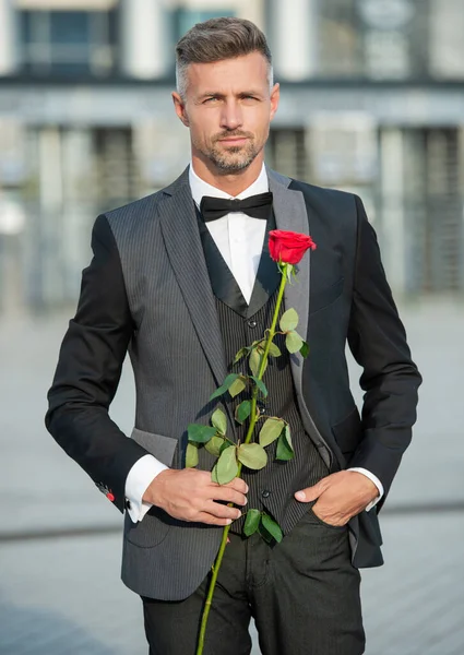 情人节的概念 穿着黑色燕尾服 头戴情人节礼物的男人站了起来 情人节的玫瑰礼物 — 图库照片