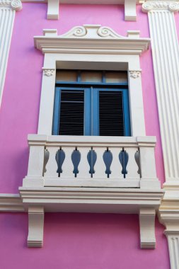 Pembe evdeki balkon parmaklıkları. Balkon korkulukları ön cephede. Balkon parmaklıkları dışarıda. Balkon parmaklıklarının fotoğrafı..