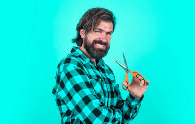 Berber dükkanı. Gülümseyen berber, makas kullan. Saç kesmek için makas kullanan moda bir adam. Kuaför salonundaki kendine güvenen adam. Erkeklik ve karizma. Sakallı hippi sakalını ve bıyığını kesti..