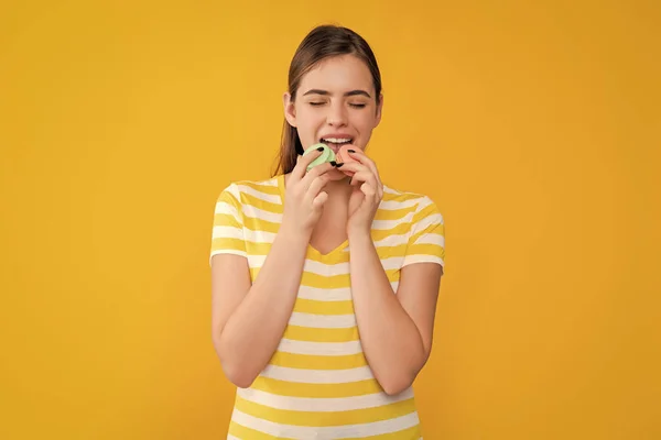 Menina Comendo Macaron Fundo Amarelo — Fotografia de Stock