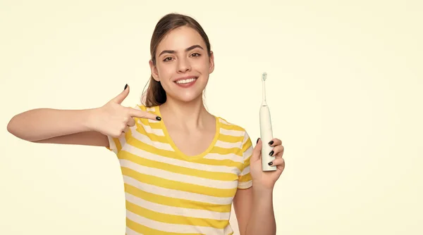 stock image happy young woman point finger on electric toothbrush isolated on white background.