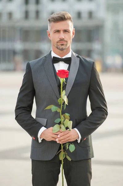 在浪漫的场合穿燕尾服的优雅男人 新郎带着浪漫的礼物 美丽的浪漫男子与玫瑰 — 图库照片