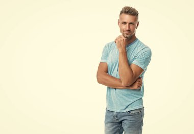 Beyaz tenli, orta yaşlı, orta yaşlı, mutlu bir adam çenesini okşuyor..