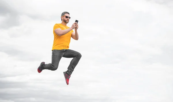 Человек Прыгать Болтать Смартфоне Фоне Неба Копировальное Пространство — стоковое фото