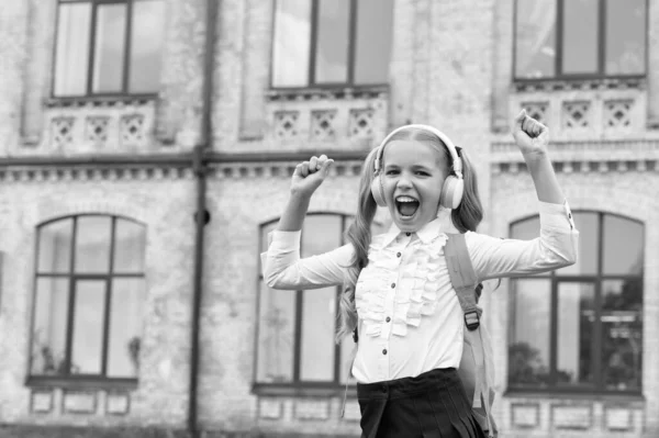 Щаслива Школярка Уніформі Робить Виграшний Жест Прослуховування Музики Навушниках — стокове фото