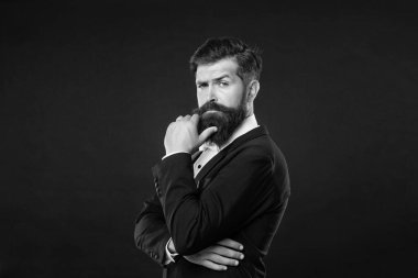 Smokin papyonlu kendine güvenen bir adam. Siyah arka planda resmi giyinmiş bir beyefendi. erkek resmi moda.
