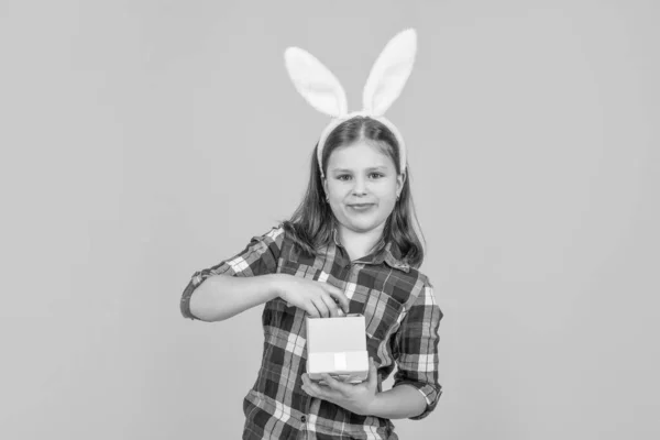 兔子耳朵里的复活节小孩打开黄色背景的礼品盒 — 图库照片