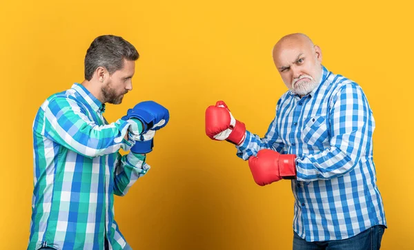 有进取心的一代男人靠背景战斗 一代男人戴着拳击手套战斗的照片 两代人孤军奋战 在演播室打架的一代男人 — 图库照片
