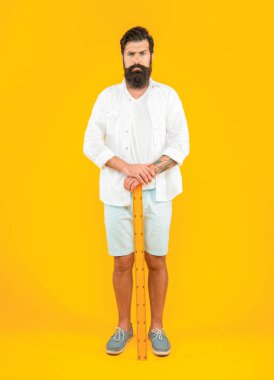 Cetvelli bir adamın fotoğrafı. Elinde cetvel olan adam sarıda izole edilmiş. Stüdyoda ölçücü cetveli olan adam. Arka planda cetveli olan adam.