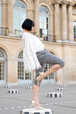 Sokakta poz veren esmer bir kadın. Esmer kadın modeli. Açık havada esmer bir kadın. Dışarıda esmer bir kadın var..