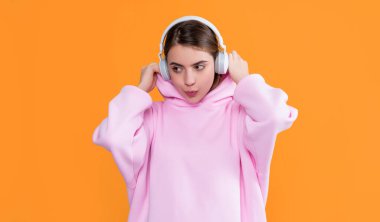 Kız sarı arka planda kulaklıkla müzik dinliyor..