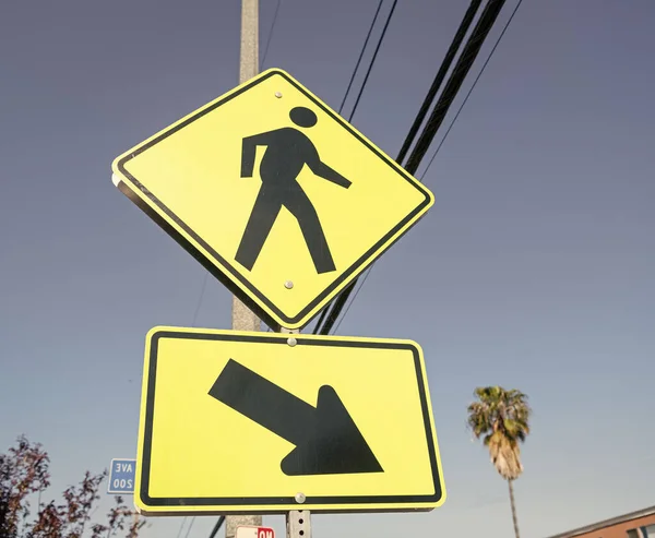 stock image yellow road sign for pedestrian directing this way.
