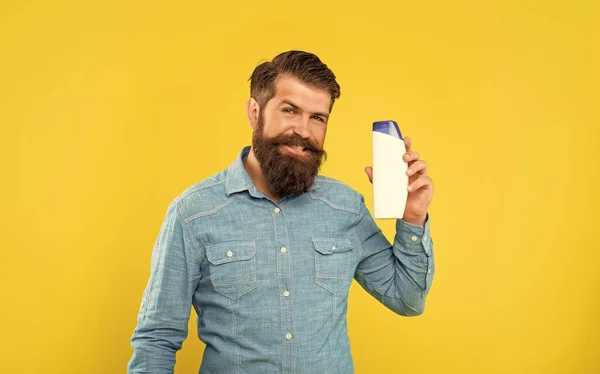Vrolijk Brutale Bebaarde Man Houden Shampoo Fles Gele Achtergrond Presenteren — Stockfoto