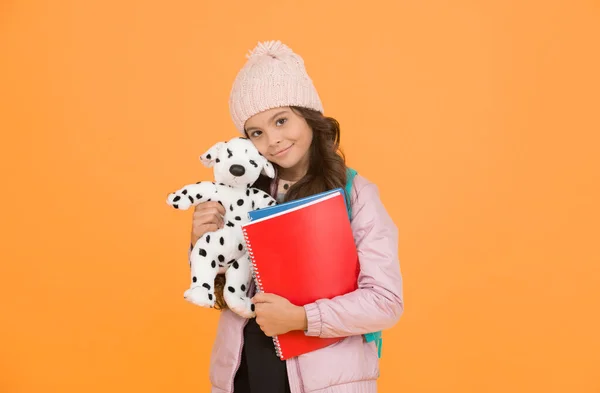 School and education. Care and treatment of animals. Studying veterinary medicine. Happy child hold toy dog and books. Little girl smile with soft toy. School classes. Toy dog. Learn and play.