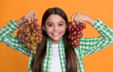 Sarı arka planda üzümlü pozitif çocuk.