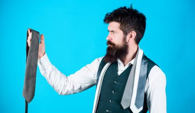 Profesyonel iş görünümünü koruyan aksesuar. Sakallı adam erkek giyim aksesuarı seçiyor. Lüks kravat aksesuarına bakan bir işadamı. Acımasız beyaz adam tutan moda aksesuar.