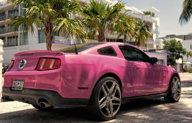 Los Angeles, Kaliforniya ABD - 14 Nisan 2021: Ford Mustang GT lüks pembe araba Palm Tree 'nin yanına park edildi. köşe görünümü.