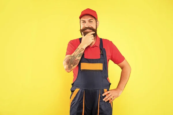 stock image cheerful bearded man repairer in work clothes on yellow background.