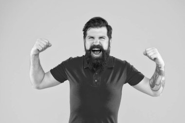 Sakallı, olgun bir hippi. Bıyıklı, vahşi beyaz adam. Sarı arka planda kendine güvenen ve yakışıklı sakallı bir adam. Saç ve sakal bakımı. Bağıran erkek portresi.