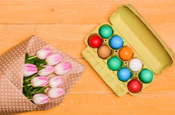 Egg hunt. Spring holiday. Holiday celebration, preparation. Tulip flower bouquet. Healthy and happy holiday. painted eggs in egg tray. Happy easter.