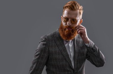 Arkadaki beyaz smokinli resmi adam. Smokin giymiş sakallı bir adamın resmi. Smokinli resmi adam Griler 'de izole edilmiş. Smokinli resmi adam stüdyoda..