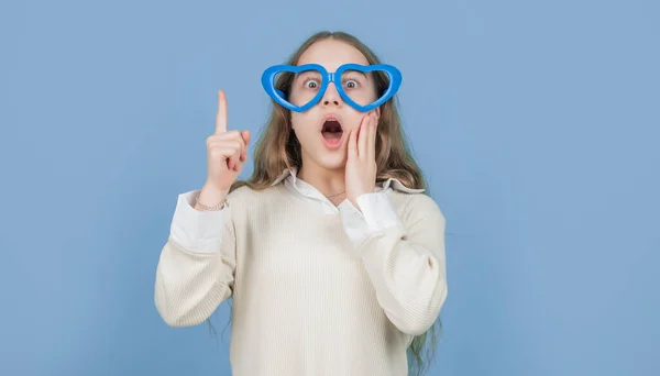Překvapené Dítě Legračních Brýlích Tvaru Srdce Držící Prst Zvednutý Modrém — Stock fotografie