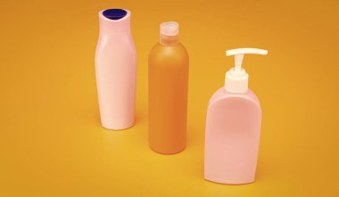 Şampuan ve vücut yıkama ürünleri için kapaklı ve pompalı çok renkli kozmetik paketleri sarı arka plan kopyalama alanı, şişeler.