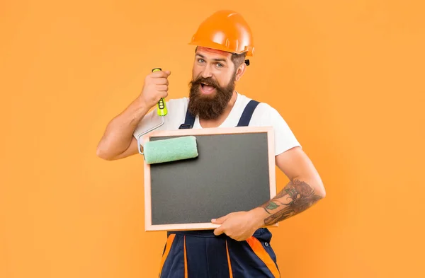 Lächelnder Mann Hausmaler Helm Und Arbeitskleidung Hält Farbroller Und Tafel — Stockfoto