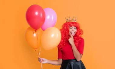 Sarı arka planda helyum balonu olan mutlu çocuk..