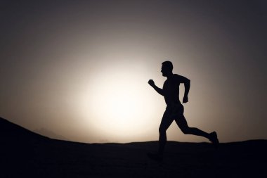 Adam dağ, spor ve Rekreasyon, geleceği ve başarı, insan ve doğa, hız ve sağlıklı yaşam günbatımı ateşli gökyüzü arka plan üzerinde çalışan siluet