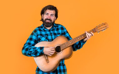 Müzik aleti. Partide gitar çalmak. Eski moda sakallı hippi telli çalgılar çalıyor. Gömlekli bir müzisyen. Klasik akustik gitarlı kendine güvenen bir şarkıcı. müzik ve vokal.