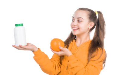 organik gıda takviyesi. Doğal ürünler ve haplar arasında seçim yapmak. Vitamin ürünü sunuyorum. Portakal aromalı hapı olan çocuk. Çocuklar için coşkulu bir tablet. Mutlu kız C vitamini sunar..