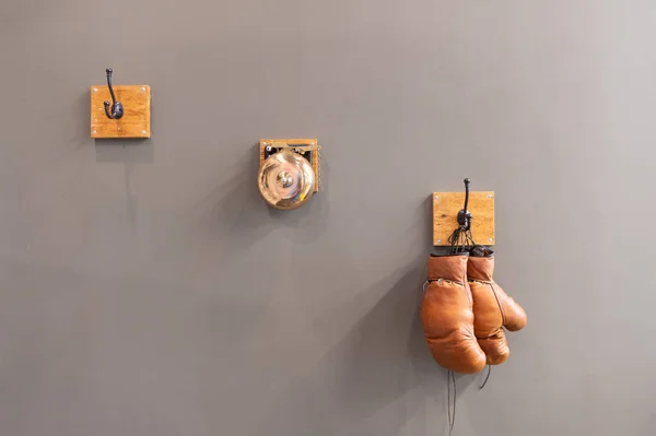 グレーのスタジオに隔離されたボクシンググローブのスポーツウェア スタジオでボクシンググローブスポーツウェア ボクシンググローブスポーツウェア ボクシンググローブスポーツウェアが壁に吊るされ — ストック写真