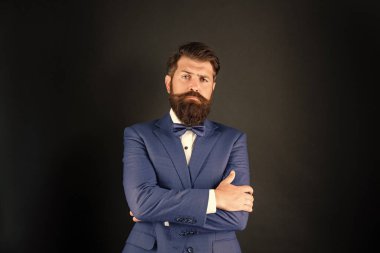 Smokin papyonlu kendine güvenen ciddi bir adam. Siyah arka planda resmi giyinen bir adam. erkek resmi moda.