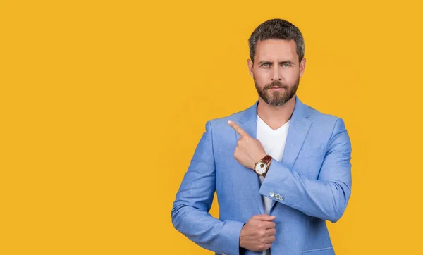 caucasian man in jacket pointing finger isolated on yellow background. man in studio. photo of handsome man wear suit. man wearing formal jacket.