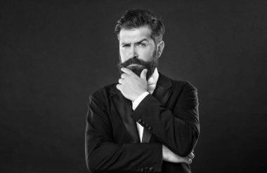 Siyah arka planda smokin giyen sakallı iş adamı, modacı..