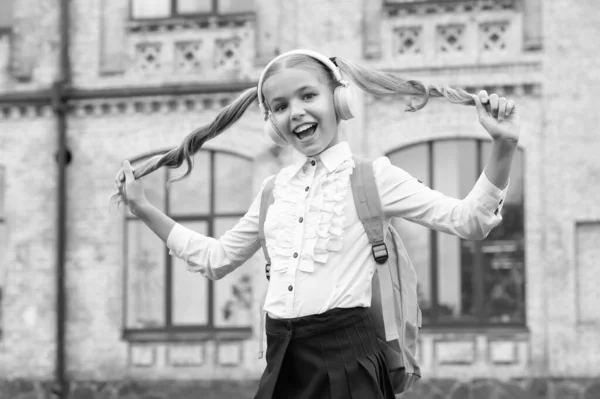 Счастливая Школьница Форме Веселится Слушая Музыку Наушниках Держа Волосы — стоковое фото