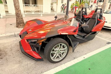 Miami Beach, Florida USA - April 15, 2021: red polaris slingshot sl, corner view. three-wheeled motorcycle. clipart