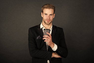 Takım elbiseli girişimci elinde kağıt kahve fincanı tutuyor..