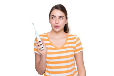 Beyaz arka planda elektrikli diş fırçası olan komik genç bir kadın..