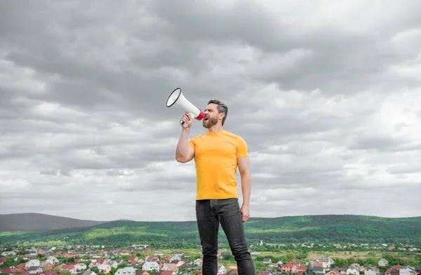 Mann Gelbem Hemd Ruft Lautsprecher Auf Himmelshintergrund Anzeige — Stockfoto