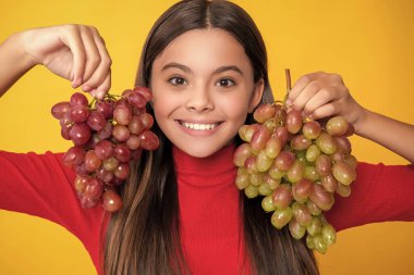 Kız gülüşü Sarı arka planda üzüm demeti.