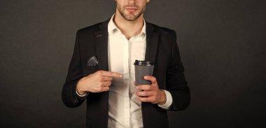 cropped businessman with coffee cup on black background, morning.