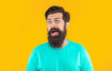 Stüdyodaki şaşkın sakallı adam. Arka plandaki sakallı adam. Bıyıklı sakallı adamın fotoğrafı. Sakallı adam sarıda izole edilmiş..