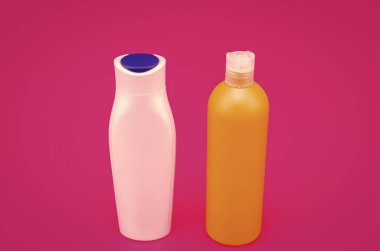 Depolama ve dağıtma için. Çok renkli ambalaj şişeleri. Pembe arka plan. Plastik losyon şişeleri. Tuvalet malzemeleri ve güzellik ürünleri için, kopyalama alanı.