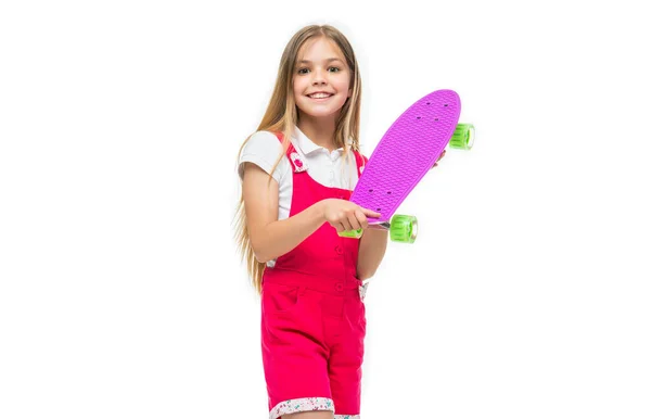 スケートボードを持つ幸せな10代の女の子は白に隔離された スタジオでスケートボードをしてる10代の女の子 スケートボードを背景に10代の女の子 スケートボードを持つ10代の女の子の写真 — ストック写真