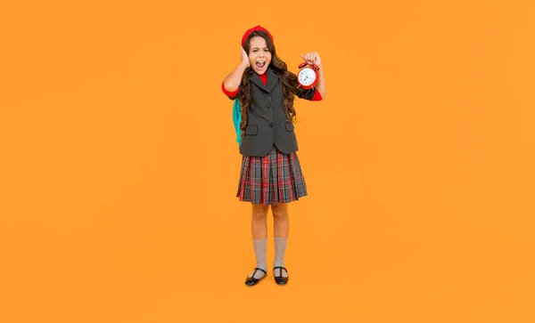 用响亮的闹钟喊着孩子 少女背着背包 回学校去知识日 教育时间 穿着制服 背景是黄色的孩子 九月一日快乐的童年 — 图库照片