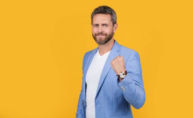 Patron fotokopi odasıyla stüdyoda. Yakışıklı patronun resmi takım elbise giyiyor. Patron resmi ceket giyiyor. Sarı arka planda izole edilmiş beyaz ceketli patron..