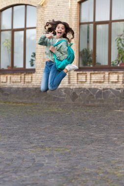 Liseli kız çocukluğunu sokakta geçirir, okula geri döner. Okul kızının çocukluk fotoğrafı sırt çantasıyla atlıyor. Kız çocukluk atlayışı. Liseli kız çocukluğunu dışarıda geçirdi..