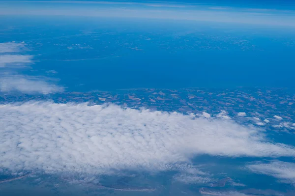 Scenic view from above. Birds-eye view. Aerial view. Elevated view. Earth landscape seen through clouds from high elevation.
